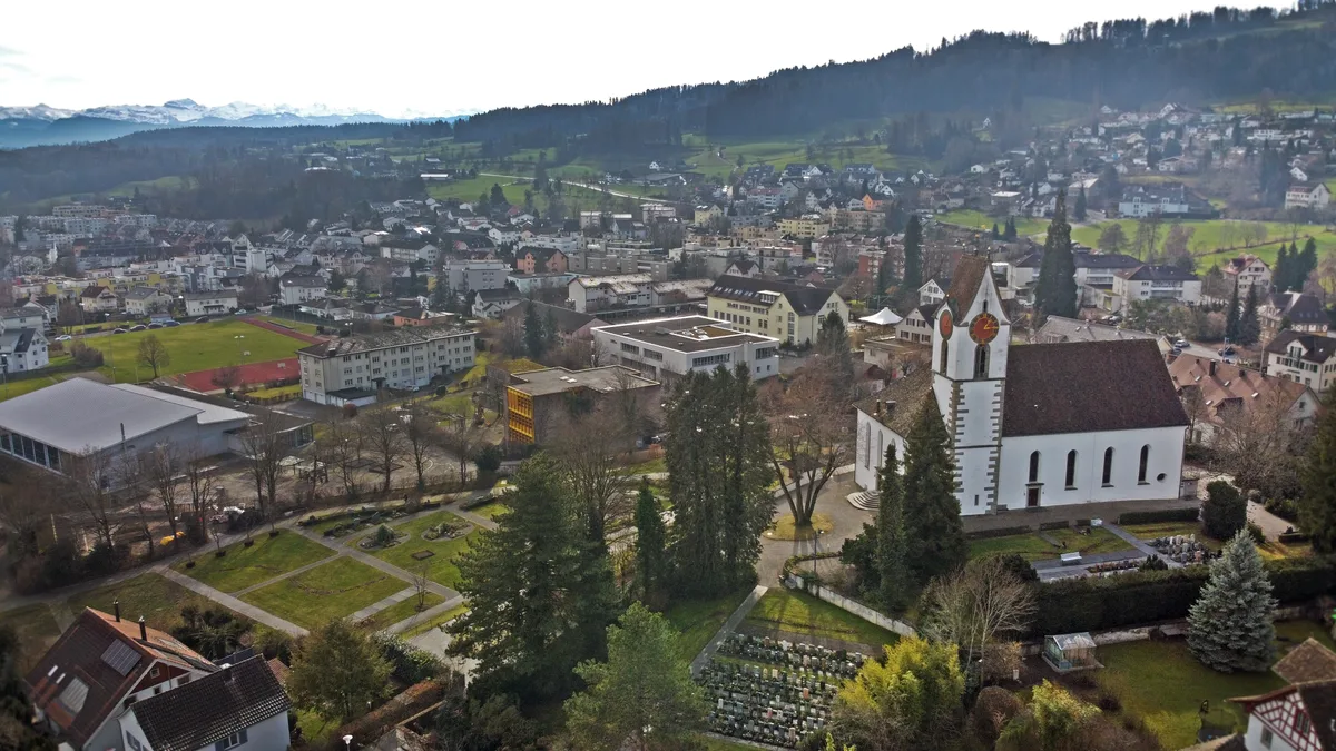 Vogelperspektive der reformierten Kirche mit Blick auf die Alpen.